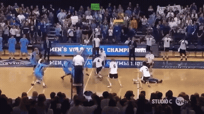 A Volleyball Game Is Being Played In Front Of A Crowd With A Sign That Says Men 'S Volleyball Champions GIF