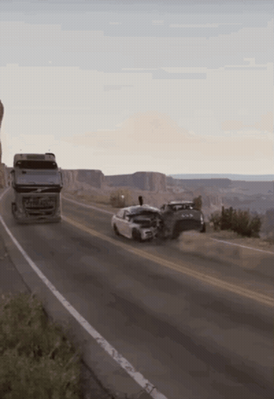 A Volvo Truck Is Driving Down The Road Next To A Car GIF