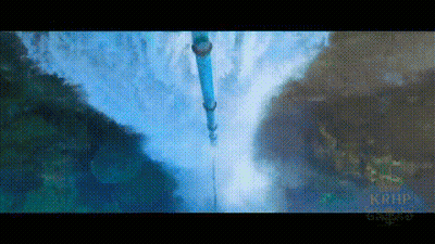 A Waterfall Is Surrounded By Mountains And Trees And A Blue Pipe Is Hanging Over It . GIF