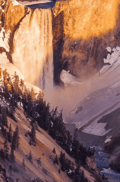 A Waterfall Is Surrounded By Trees And Rocks GIF