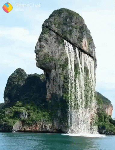 A Waterfall That Looks Like A Statue Of A Man 'S Head GIF