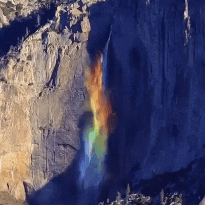 A Waterfall With A Rainbow In The Background GIF