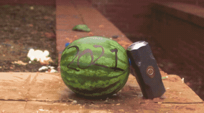A Watermelon With The Year 2021 Painted On It Sits Next To A Hammer GIF