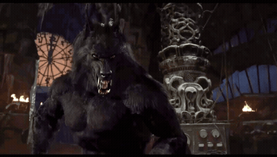 A Werewolf Is Standing In Front Of A Ferris Wheel And A Statue GIF