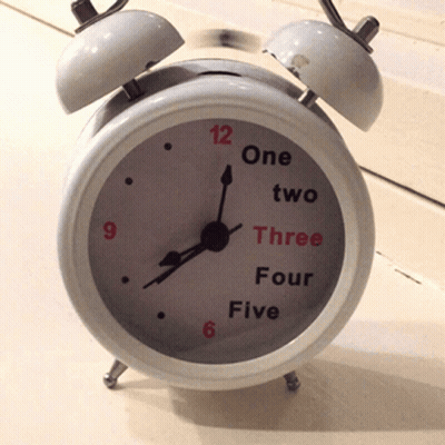A White Alarm Clock That Says One Two Three Four And Five On The Face GIF