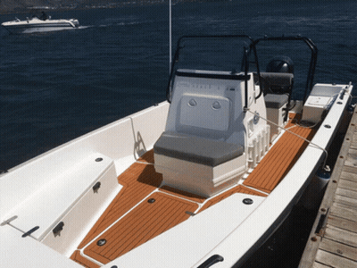 A White Boat With A Yamaha Motor Sits On A Dock GIF