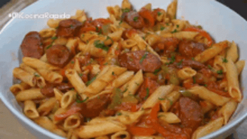 A White Bowl Filled With Pasta , Sausage And Vegetables GIF