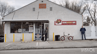 A White Building With A Red Sign That Says Food Patrol Etc GIF
