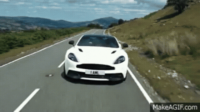 A White Car Is Driving Down A Country Road . GIF