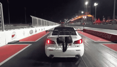 A White Car Is Driving Down A Race Track With A Bahraingp.com Sign Behind It GIF