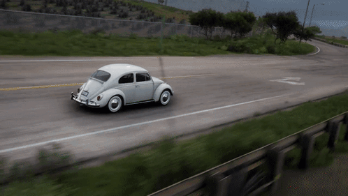 A White Car Is Driving Down A Road With The Letter Z On The Side Of It GIF