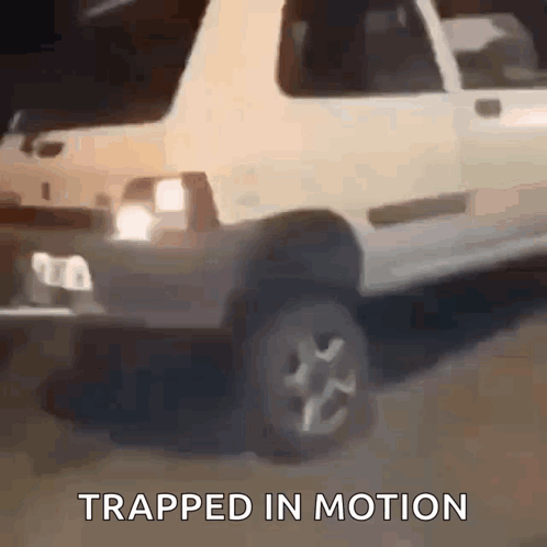 A White Car Is Driving Down A Road With The Words Trapped In Motion Written Below It . GIF