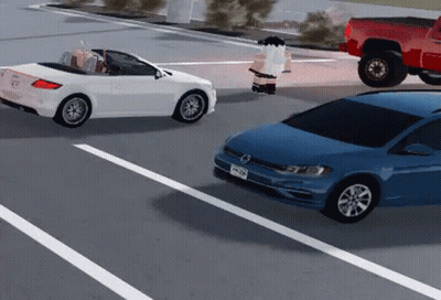 A White Car Is Driving Down A Street Next To A Blue Car . GIF