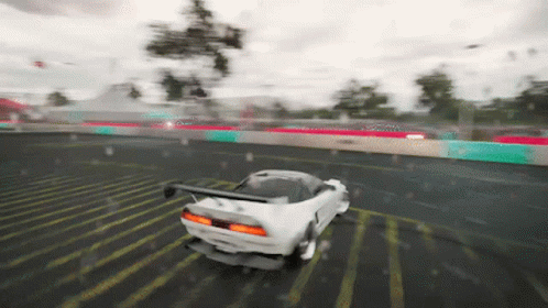 A White Car Is Driving Down A Wet Road In The Rain GIF