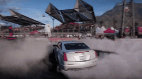 A White Car Is Driving Through A Dirt Field GIF
