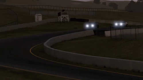 A White Car With A Black Roof Is Driving Down A Road At Night GIF
