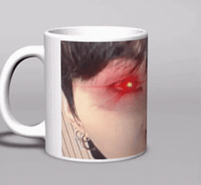 A White Coffee Mug With A Picture Of A Woman 'S Face With Red Eyes GIF