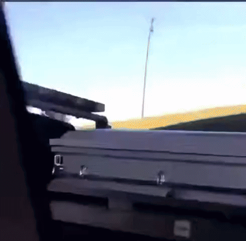 A White Coffin Is Sitting In The Back Of A Truck GIF
