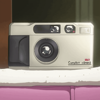 A White Compact Camera Is Sitting On A Pink Couch GIF