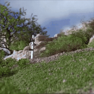 A White Cross In The Middle Of A Grassy Hill GIF