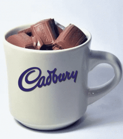 A White Cup With Cadbury Written On It Filled With Chocolate GIF