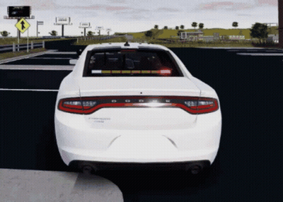 A White Dodge Charger Is Driving Down The Road GIF