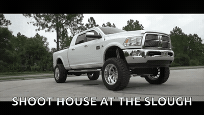 A White Dodge Ram Truck Is Parked On The Side Of The Road . GIF