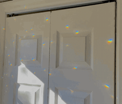 A White Door With A Reflection Of A Rainbow GIF