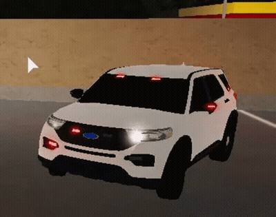 A White Ford Explorer Police Car Is Driving Down A Road . GIF