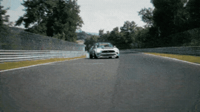 A White Ford Mustang Is Driving Down A Track GIF