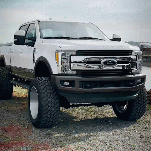 A White Ford Truck Is Parked In The Dirt GIF