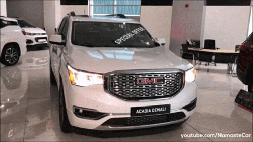 A White Gmc Acadia Denali With A Special Offer On The Windshield GIF