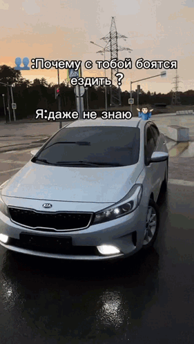 A White Kia Car Is Parked On The Side Of A Road GIF