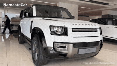 A White Land Rover Defender In A Showroom GIF