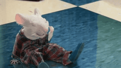 A White Mouse Is Sitting On The Floor Wearing Plaid Pajamas GIF