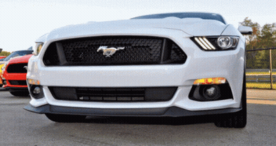 A White Mustang Is Parked In A Parking Lot Next To A Red Mustang GIF