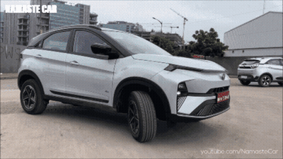 A White Namaste Car Is Parked In A Parking Lot Next To Another Car GIF