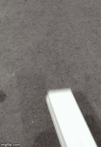 A White Object Is Sitting On A Carpet On The Floor . GIF