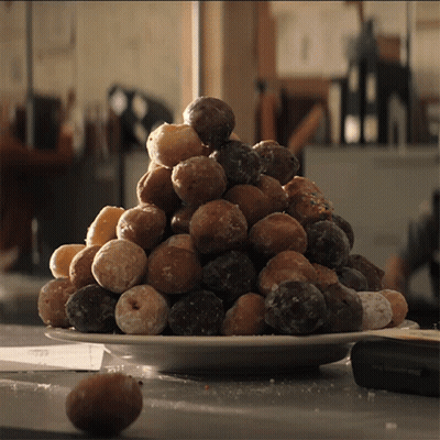 A White Plate Filled With A Variety Of Donuts GIF