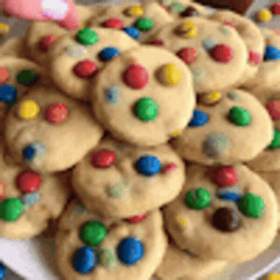 A White Plate Topped With A Bunch Of Cookies With Colored Dots On Them . GIF