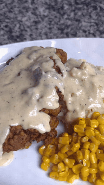 A White Plate Topped With Fried Chicken And Corn GIF