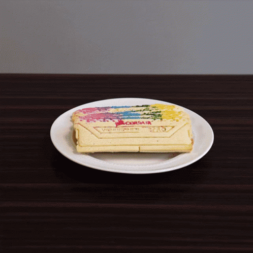 A White Plate With A Piece Of Cake On It With The Word Corsair On It GIF