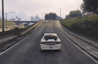 A White Police Car Is Driving Down A Road GIF