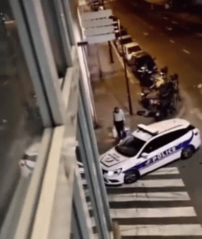 A White Police Car Is Parked On The Side Of The Road . GIF