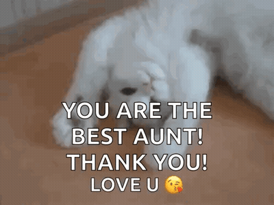 A White Puppy Is Laying On The Floor With Its Paws On Its Face . GIF