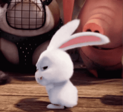 A White Rabbit With Pink Ears Is Standing On A Wooden Surface GIF