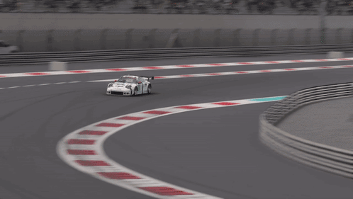 A White Race Car With The Number 14 On The Side Is Driving On A Track GIF