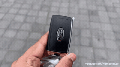 A White Range Rover Velar Is Parked On A Cobblestone Driveway . GIF