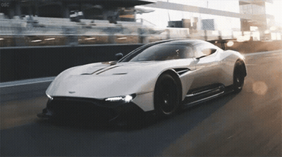 A White Sports Car Is Driving Down A Race Track With The Letters Oso On The Bottom GIF