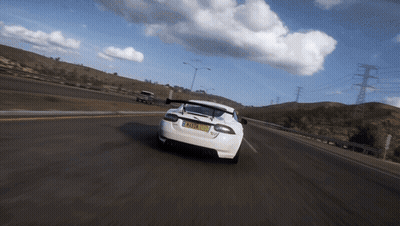 A White Sports Car Is Driving Down A Road With A License Plate That Says Tmz - Xm GIF